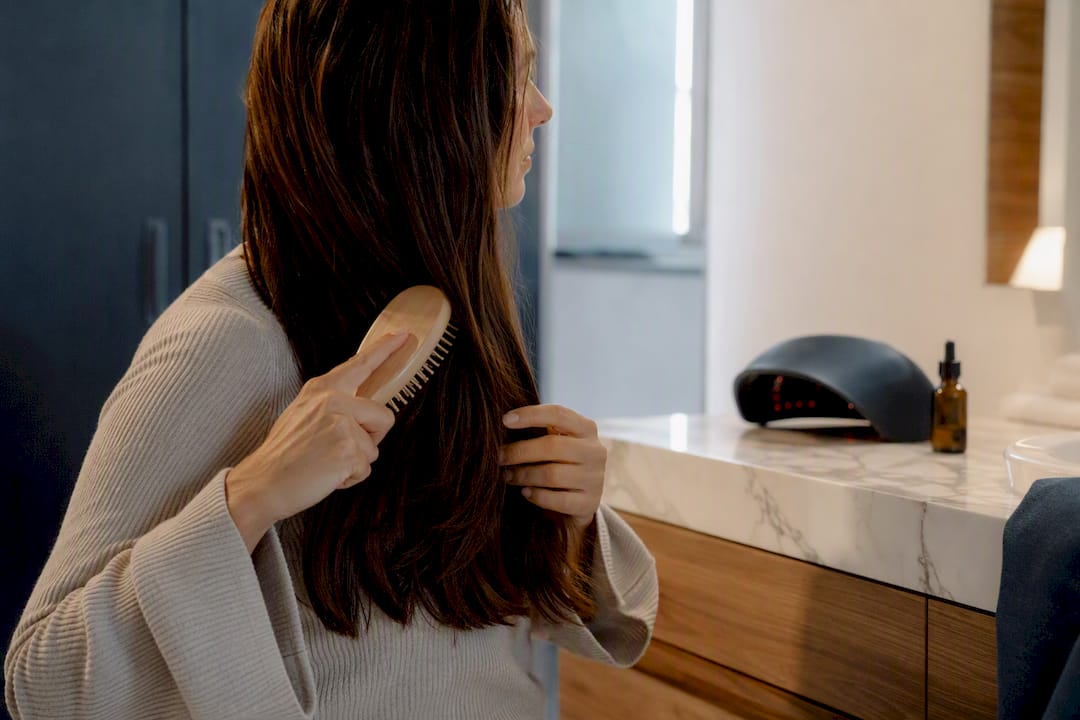 Woman gently brushing hair to reduce breakage
