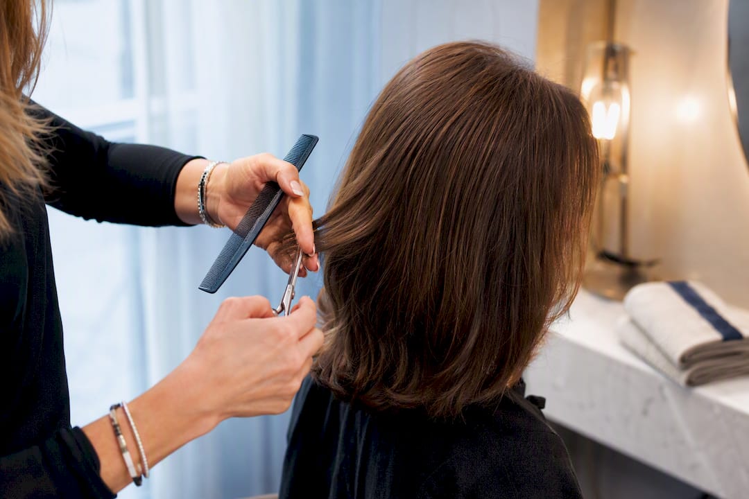 Stylist shaping hair to conceal thinning