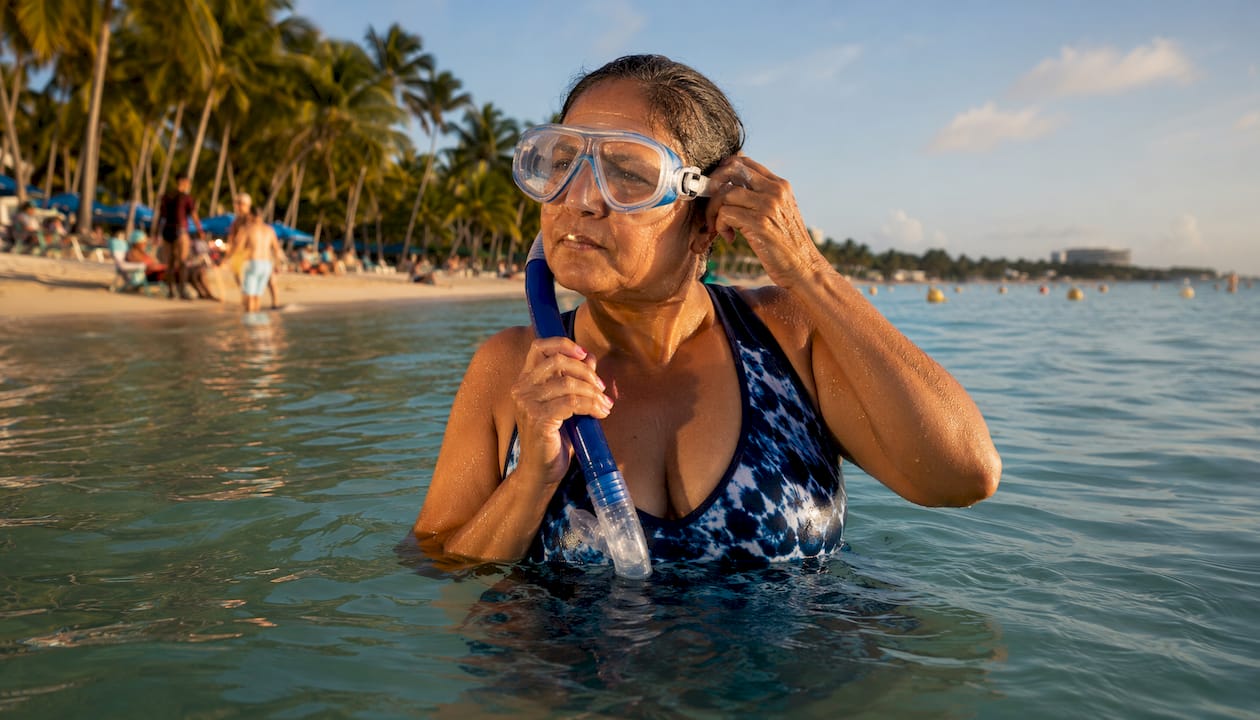 Snorkeler adjusting prescription mask in shallow water