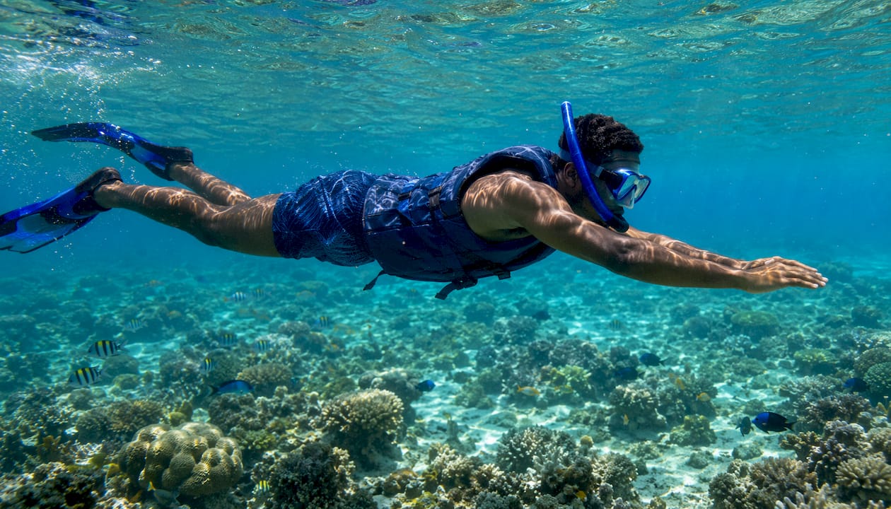 Overhead view snorkeler practicing slow breathing over reef