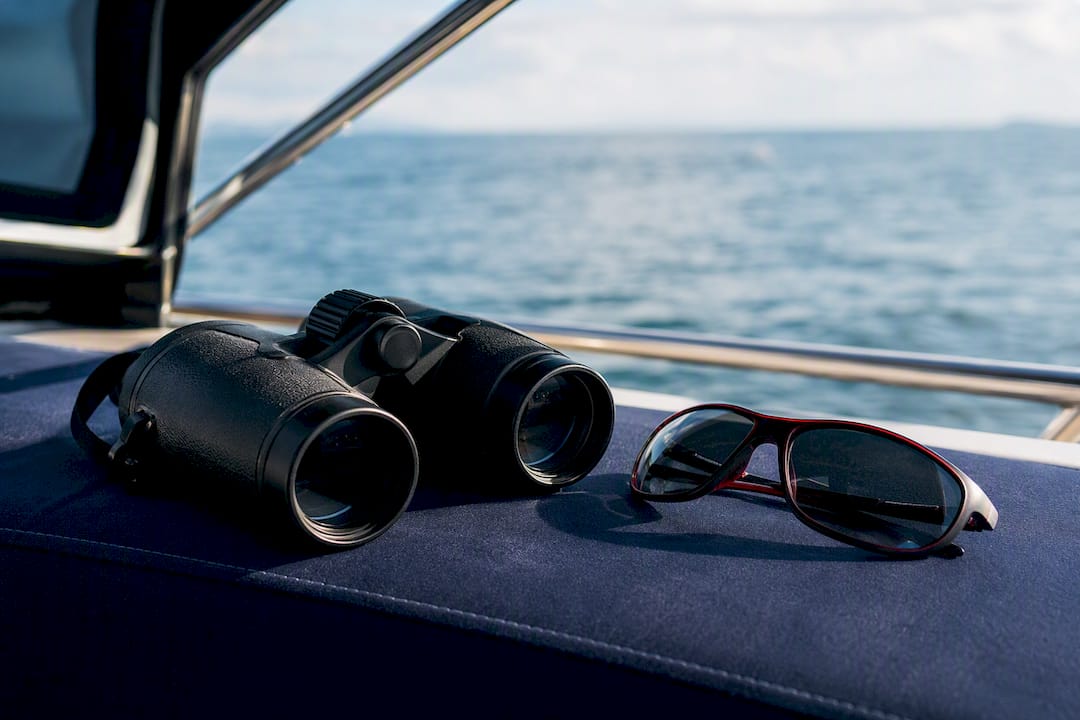 Binoculars and sunglasses on boat deck