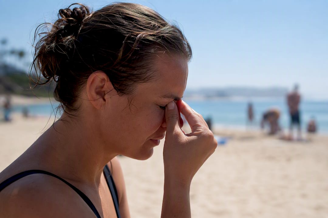 Person with watery eyes on beach