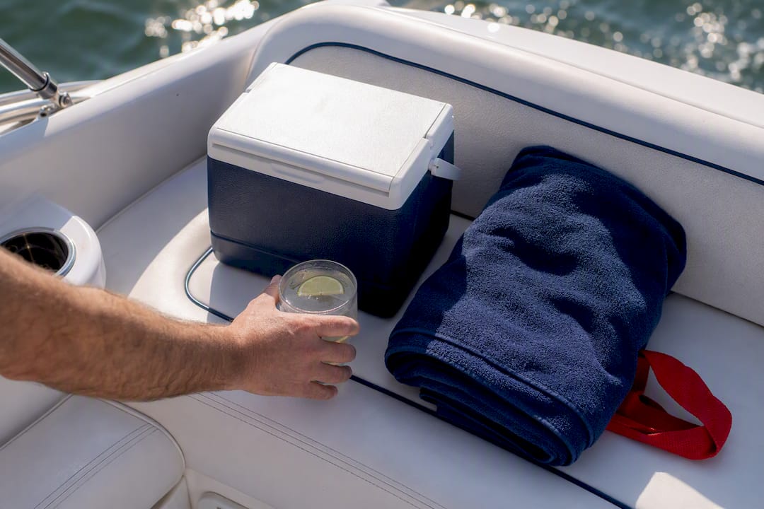 Passenger drink beside cooler on boat