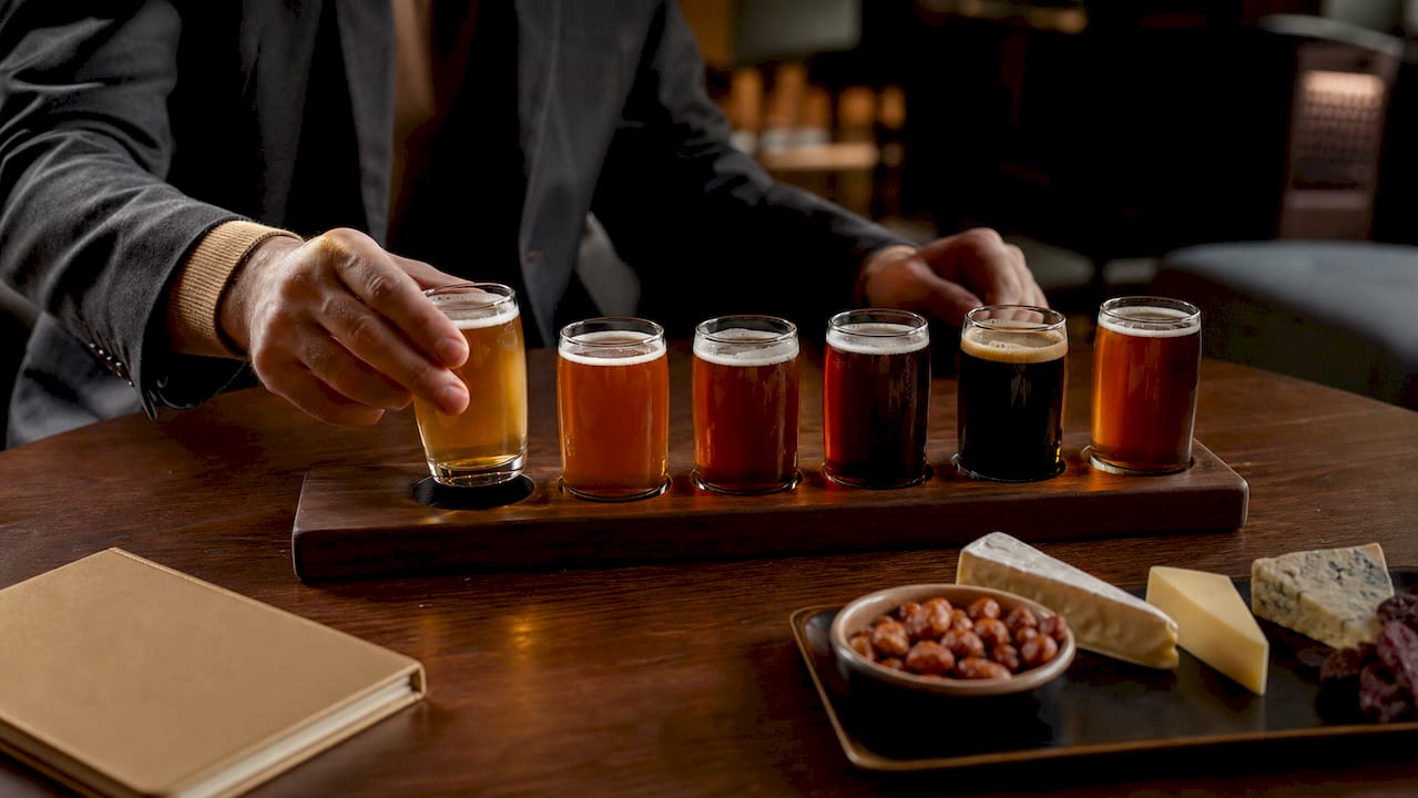 Hands holding scorecard next to beer flight