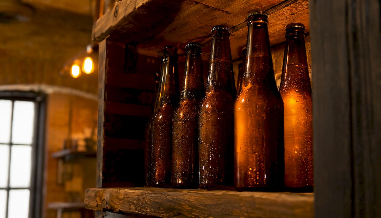 Row of brown glass beer bottles in cellar