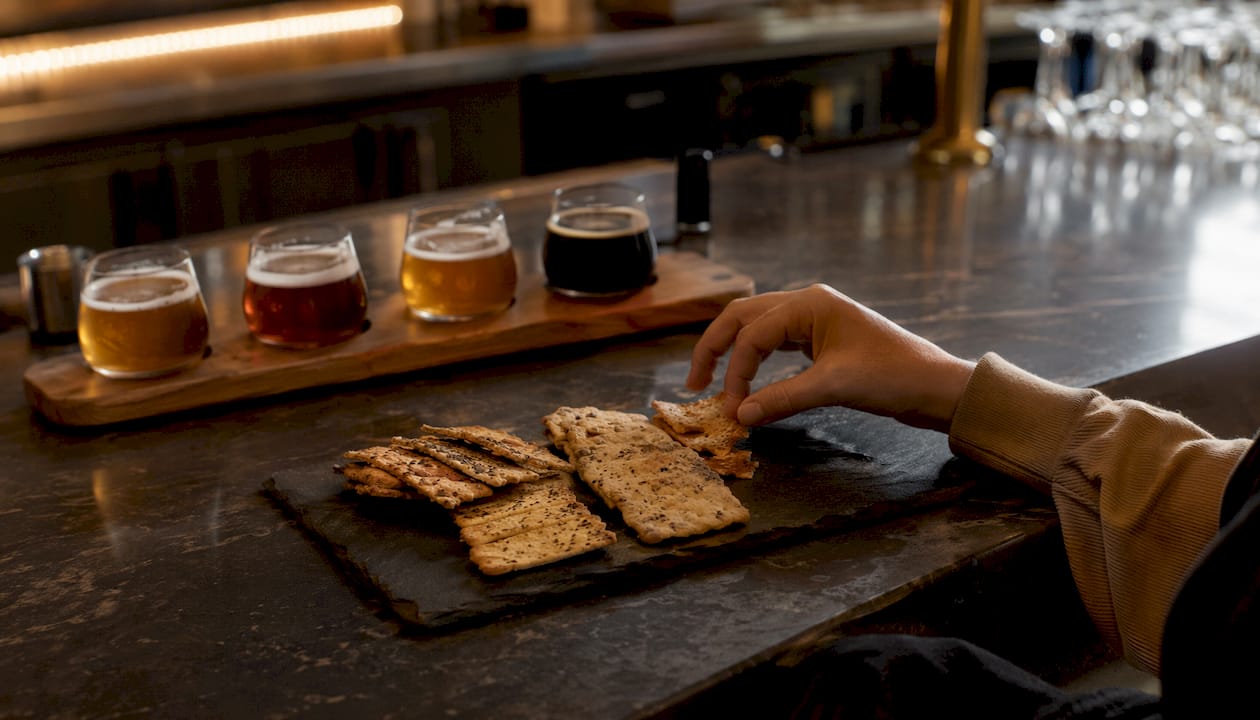 Neutral crackers next to beer flight samples for palate cleansing