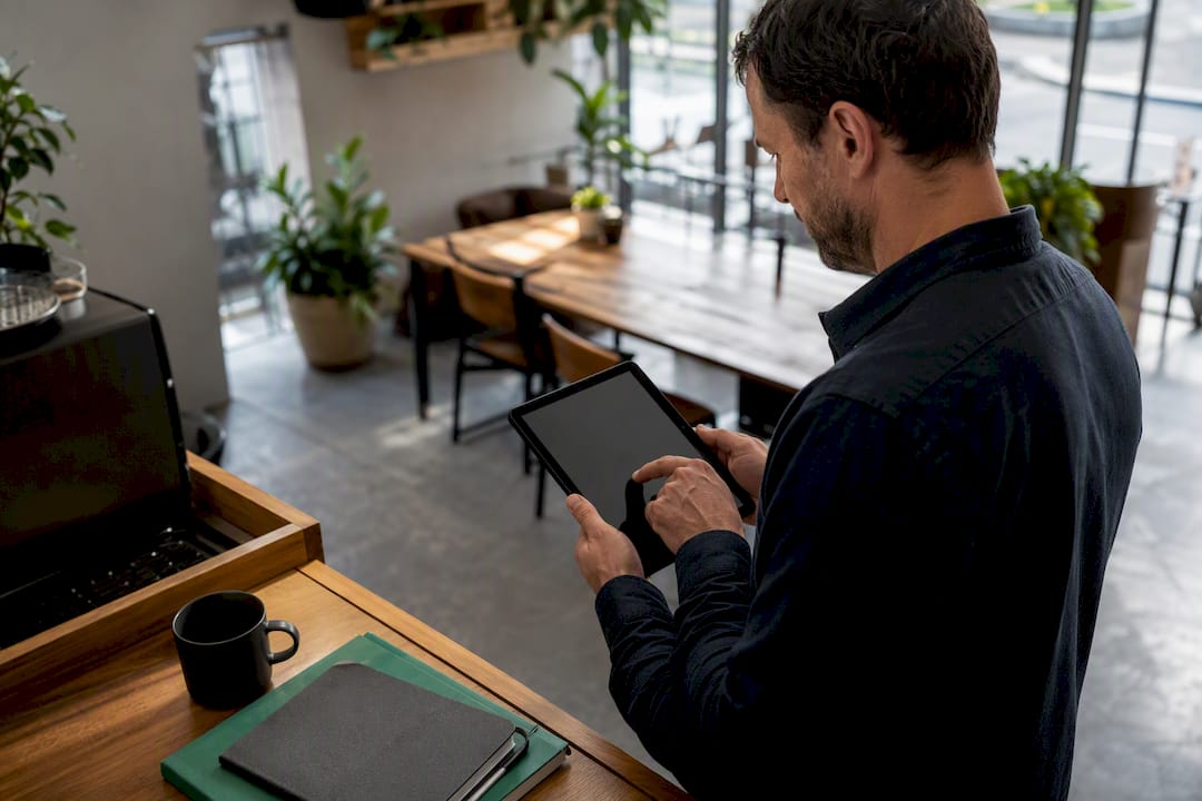 Hands writing deposit and balance on tablet