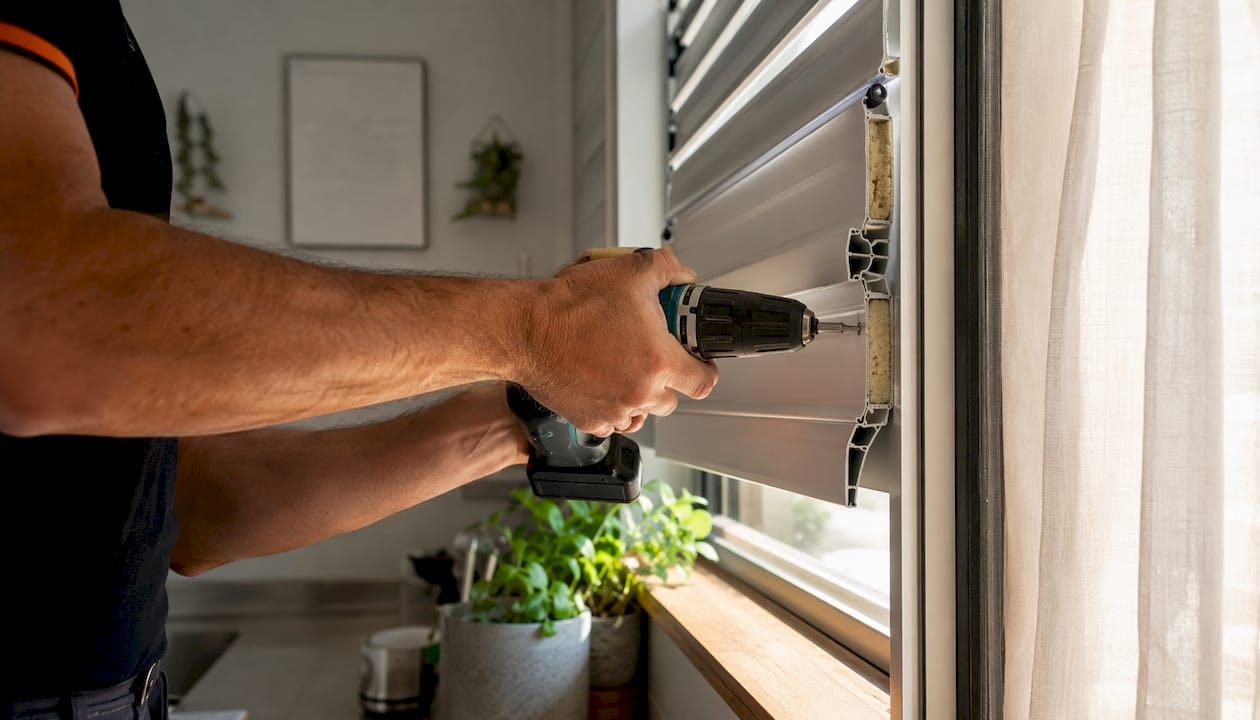 Hands installing insulated roller shutter slats