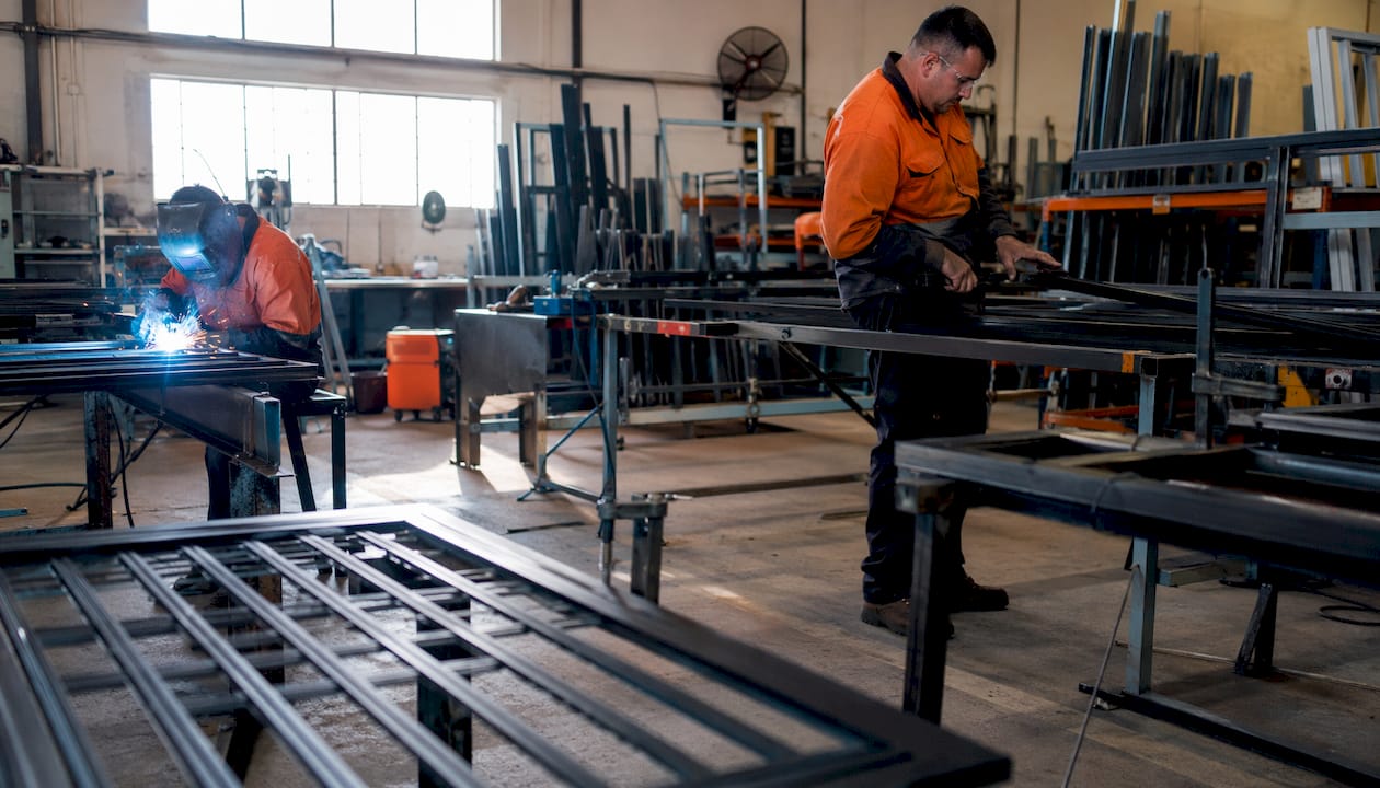 Security door factory with workers assembling frames