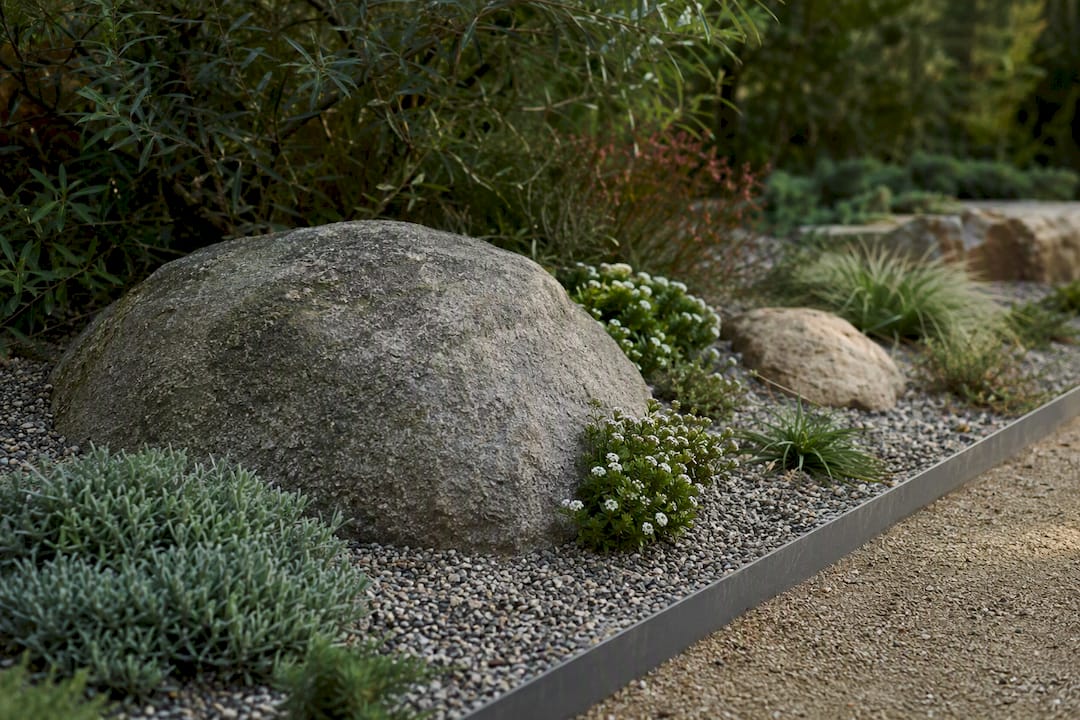 Partially buried boulder in mature rock garden