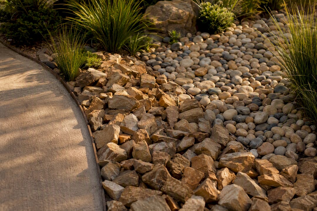 Mudstone and river pebbles in garden bed