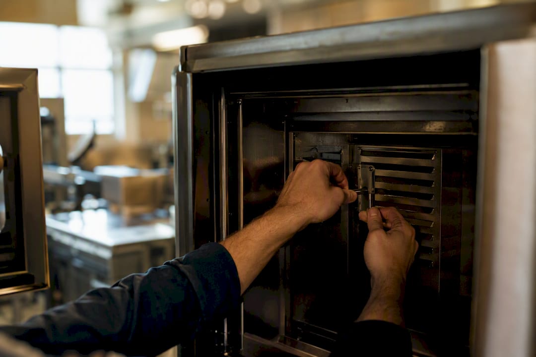 Hands adjusting airflow damper inside commercial oven
