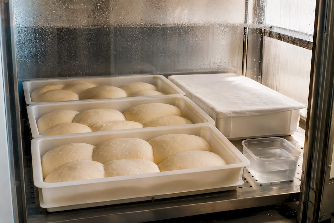 Dough trays rising in a bakery proofer
