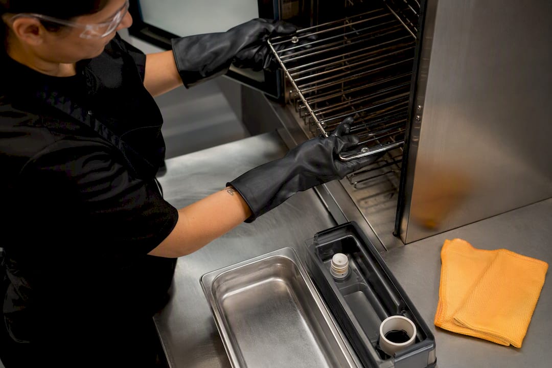 Operator preparing combi oven for descaling
