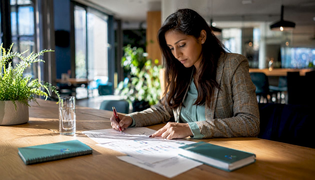 Woman reviewing unpaid invoices in UK office