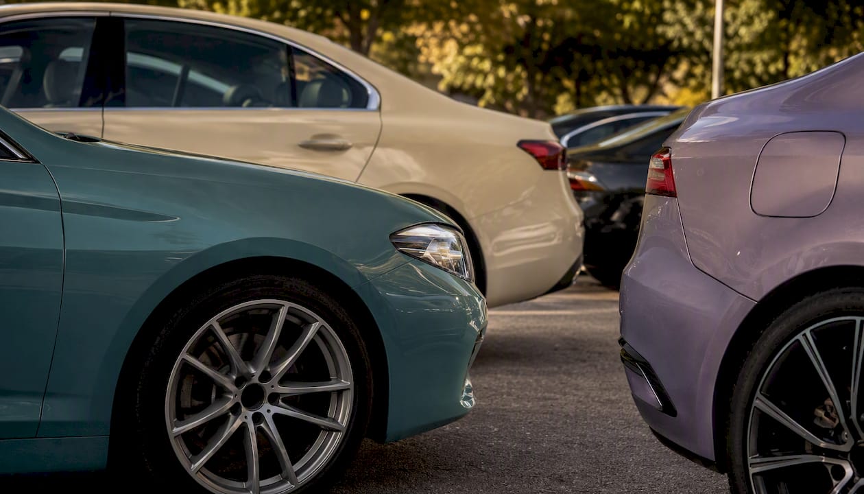 Partial views of cars in varied paint colors