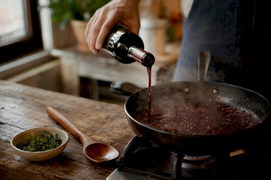 Pouring wine into hot pan for sauce
