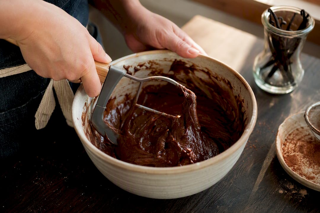 Flat beater mixing cake batter in bowl