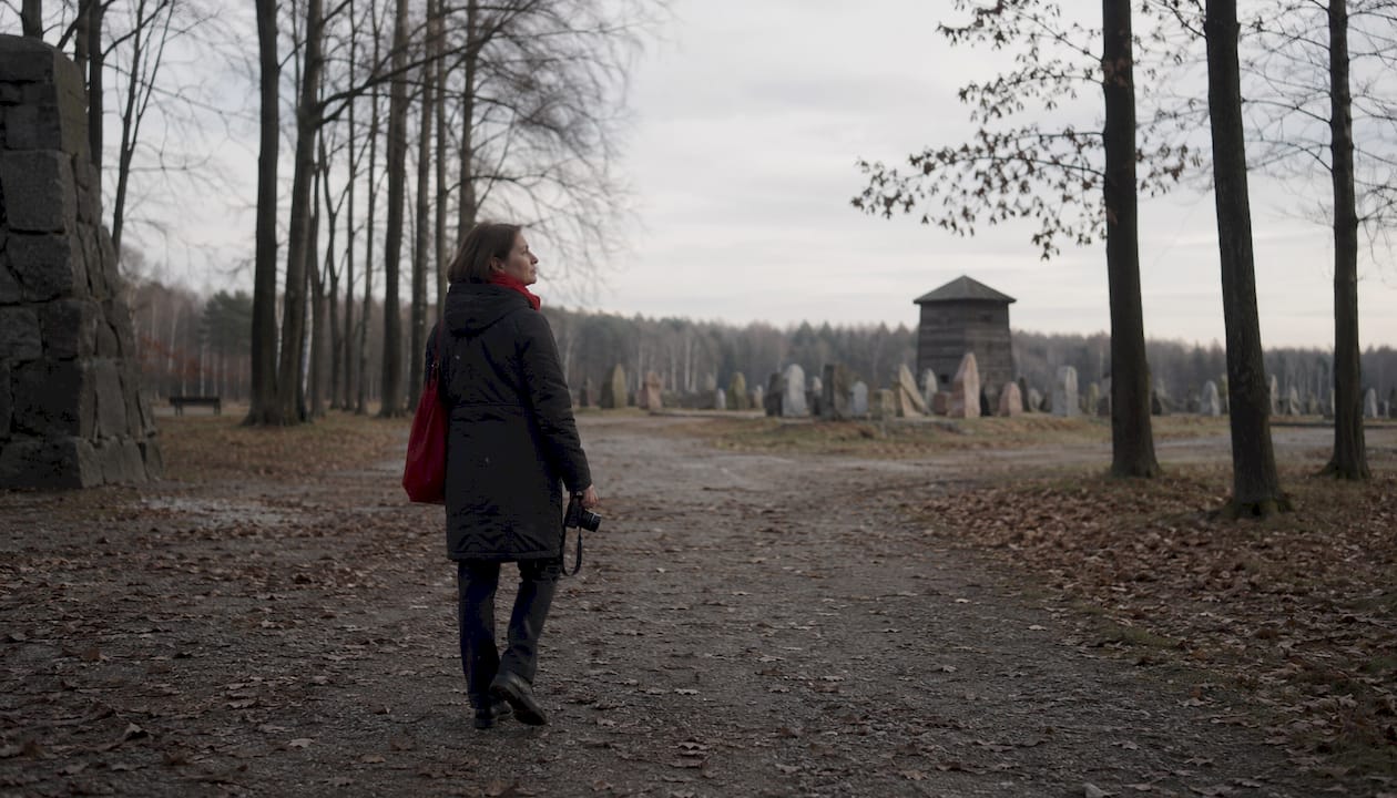 Visitor walking respectfully along Birkenau barracks