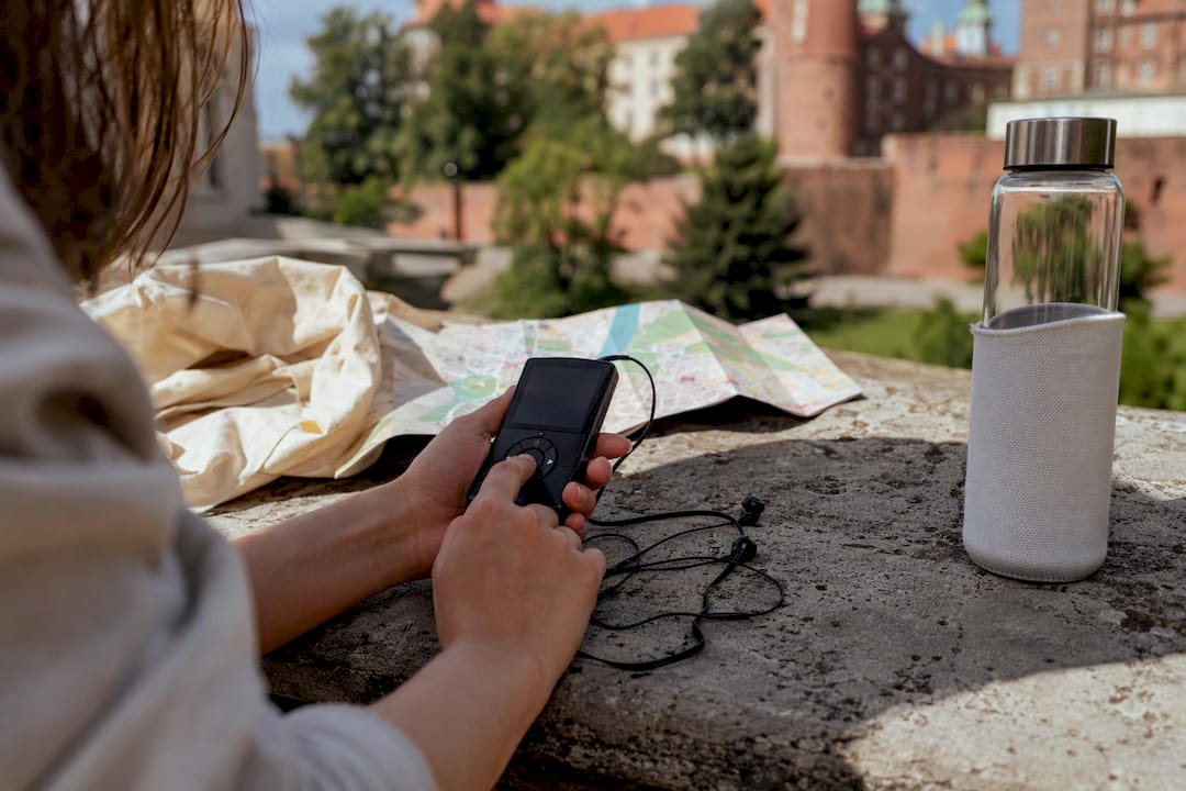 Hands adjusting portable audio tour guide device