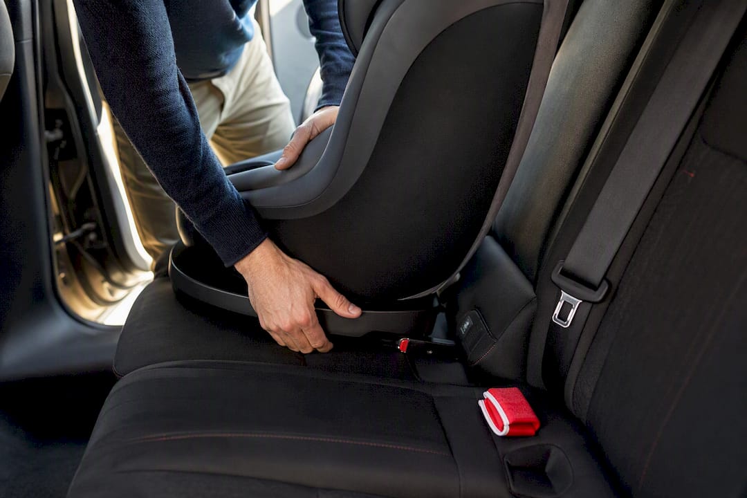 Hands securing child restraint anchors