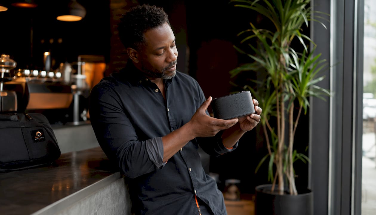 Hands holding Audio Pro wireless speaker in store
