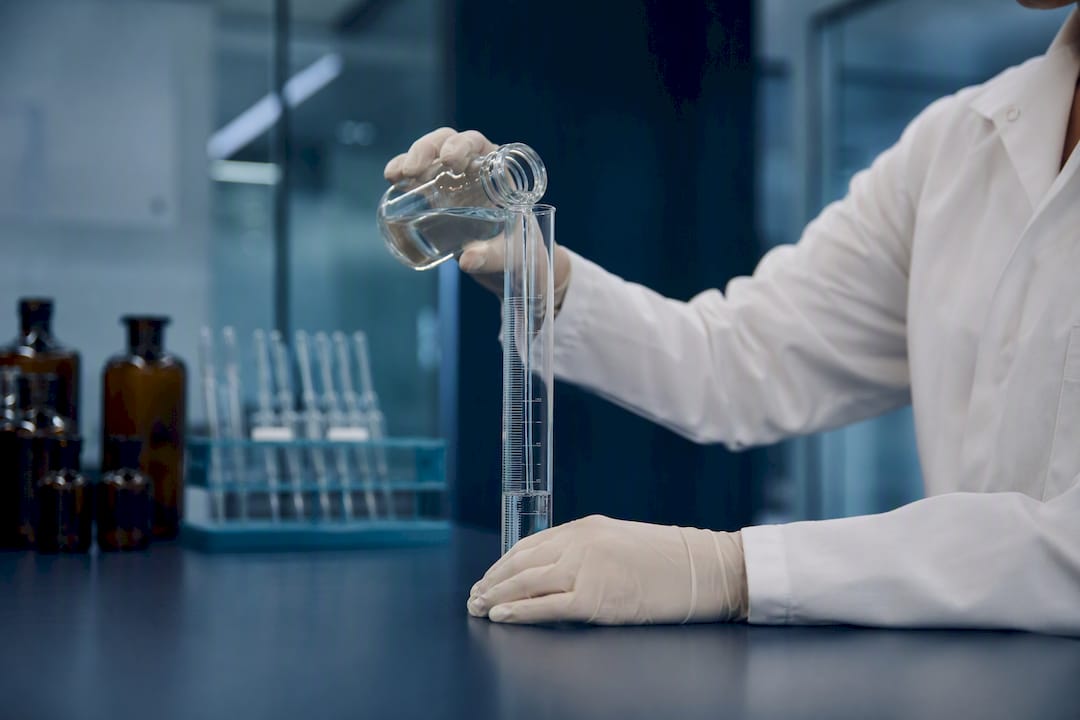 Lab technician measuring liquid chemical excipient