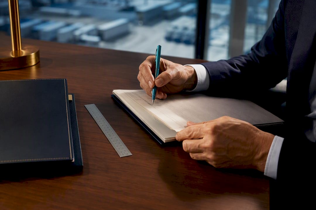 Hands drafting a logistics sale covenant