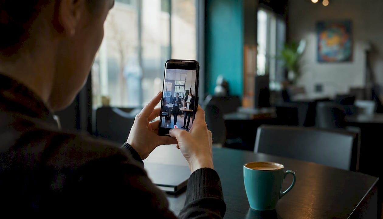 Hands filming vertical drama series on smartphone