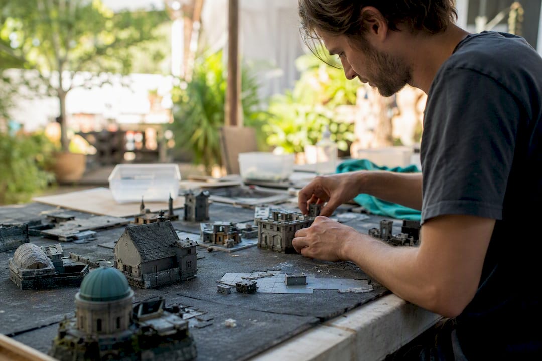 Hands arranging miniature production sets