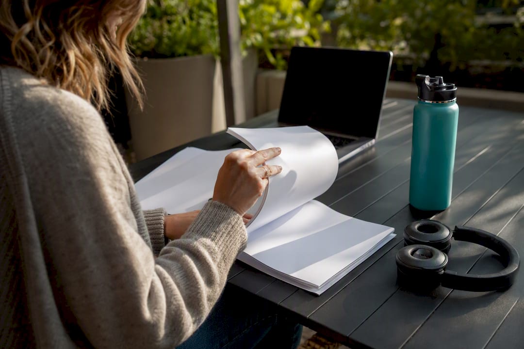 Hands flipping through scripts in a home studio workflow