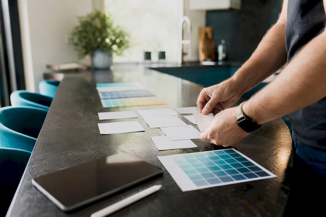Hands arranging thumbnail mockups and color swatches