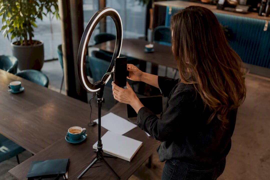 Hands adjusting phone tripod and ring light