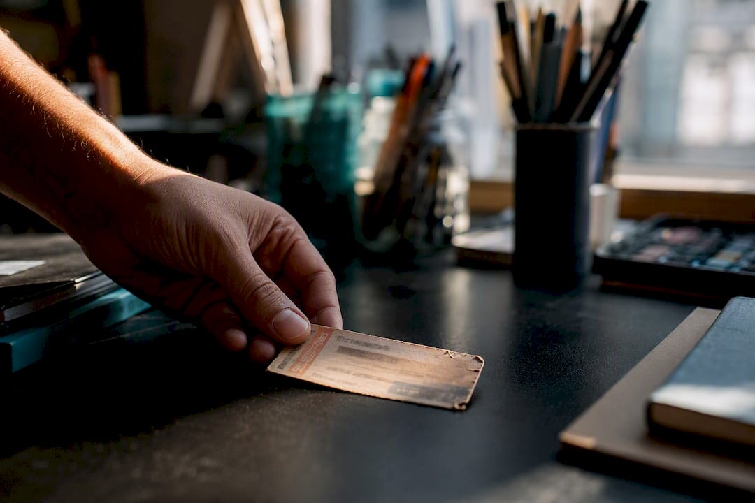 Hand placing crumpled receipt on dark surface