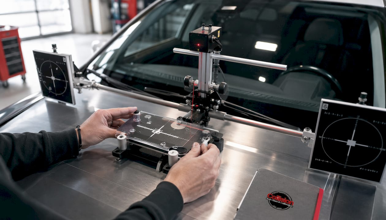 Close-up of hands adjusting ADAS calibration tools