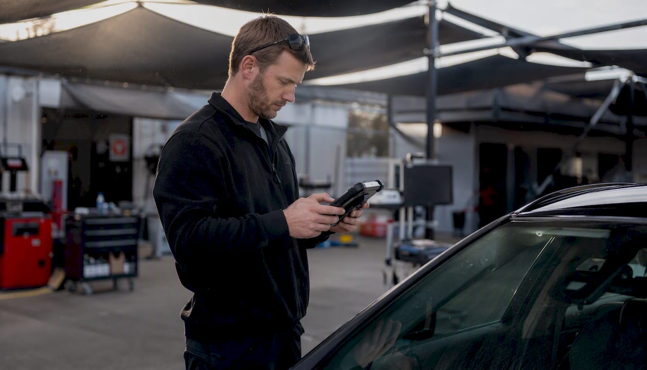 Technician verifying ADAS calibration after windshield replacement