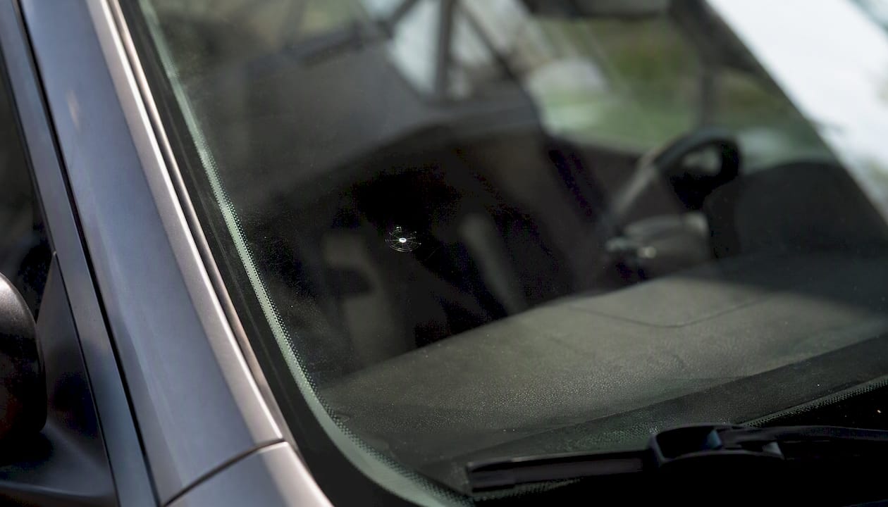 Close-up windshield showing bullseye chip near driver vision zones