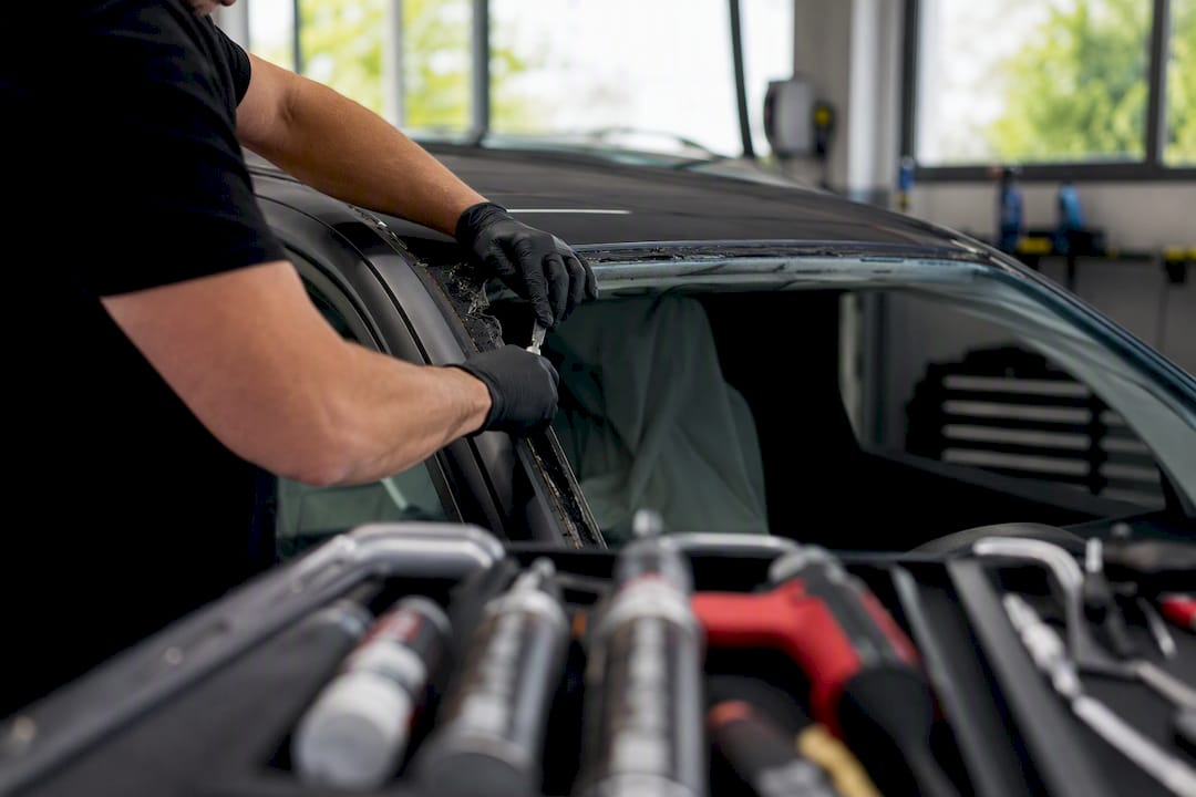Technician prepping windshield frame for adhesive
