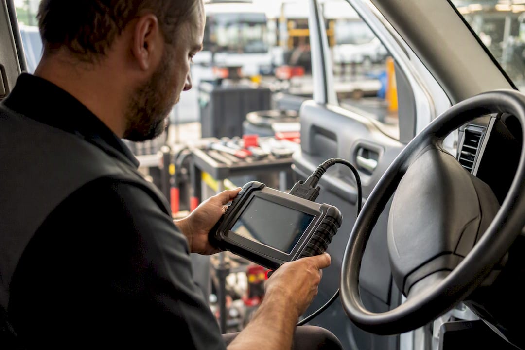 Technician scanning vehicle after windshield calibration