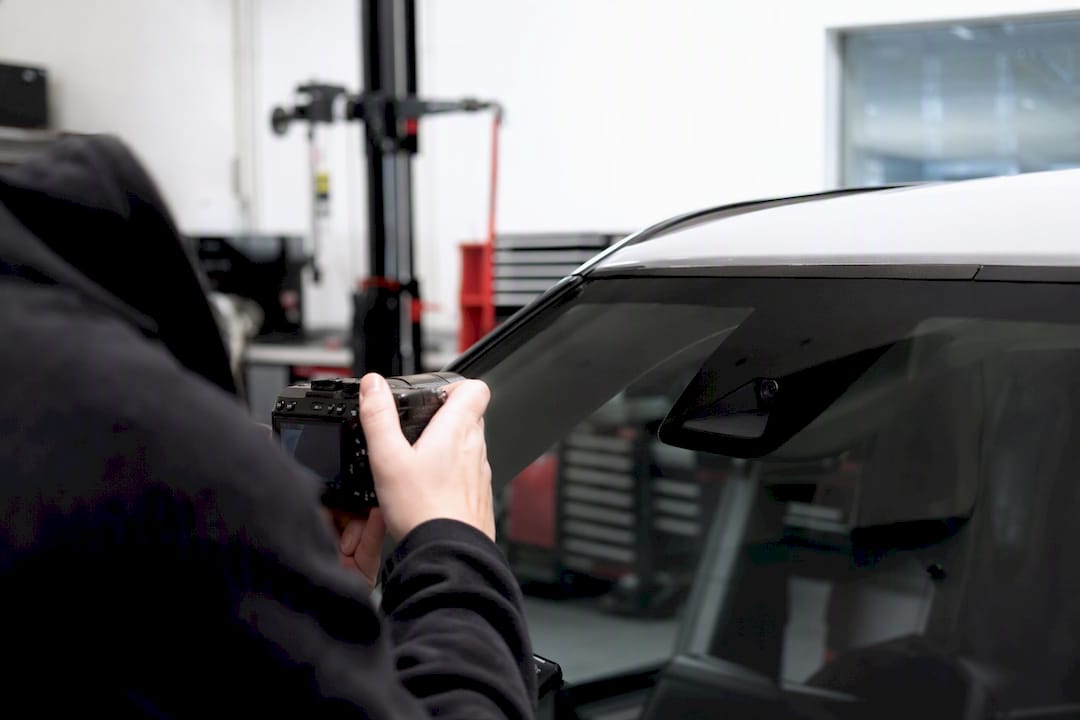Technician photographing windshield camera area