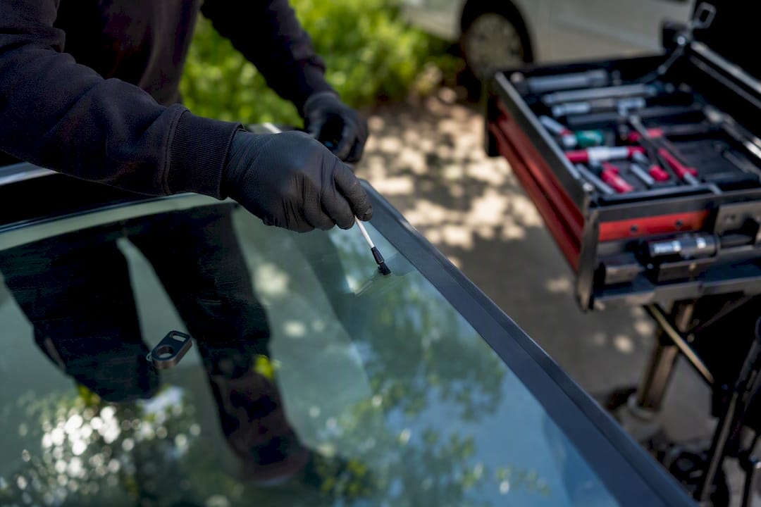 Close-up of technician brushing primer onto windshield edge