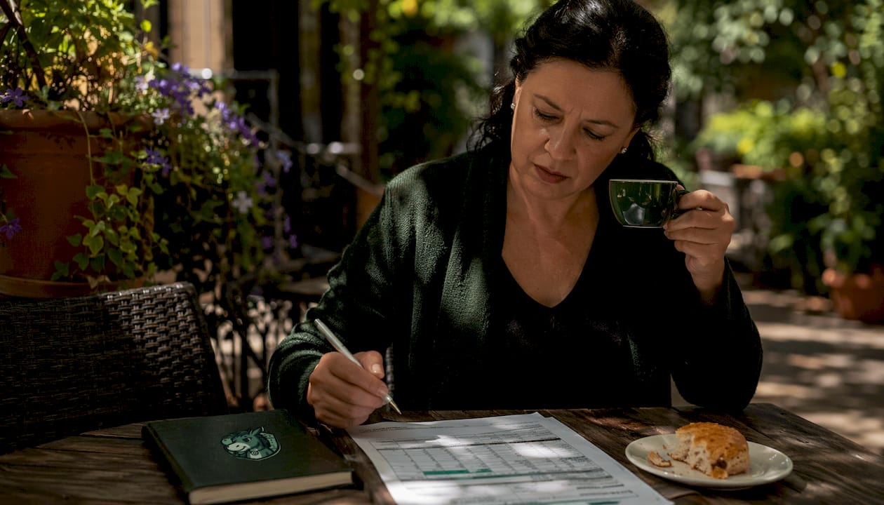 Woman studying lay betting stats in café
