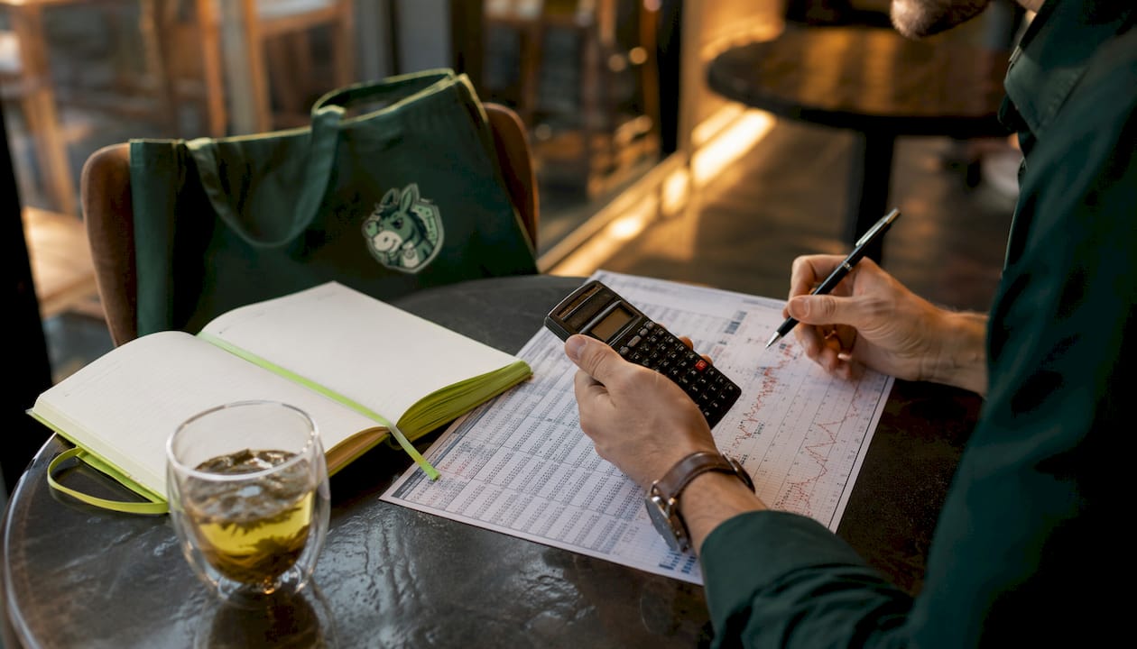Hands analyzing horse race odds on paper at café table