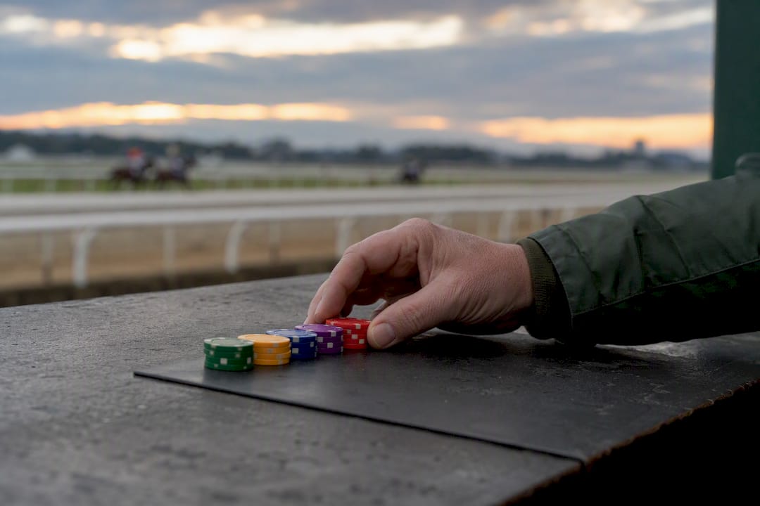Hand moving betting chips at race track