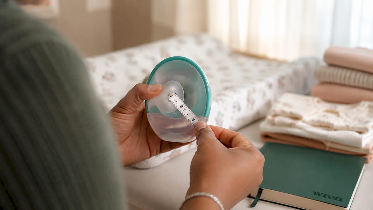 Close-up measuring nipple diameter with tape