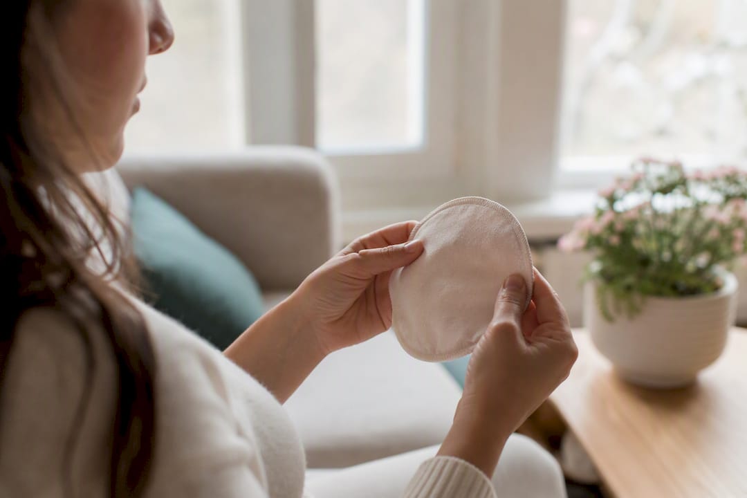 Hands holding breast pad to window light