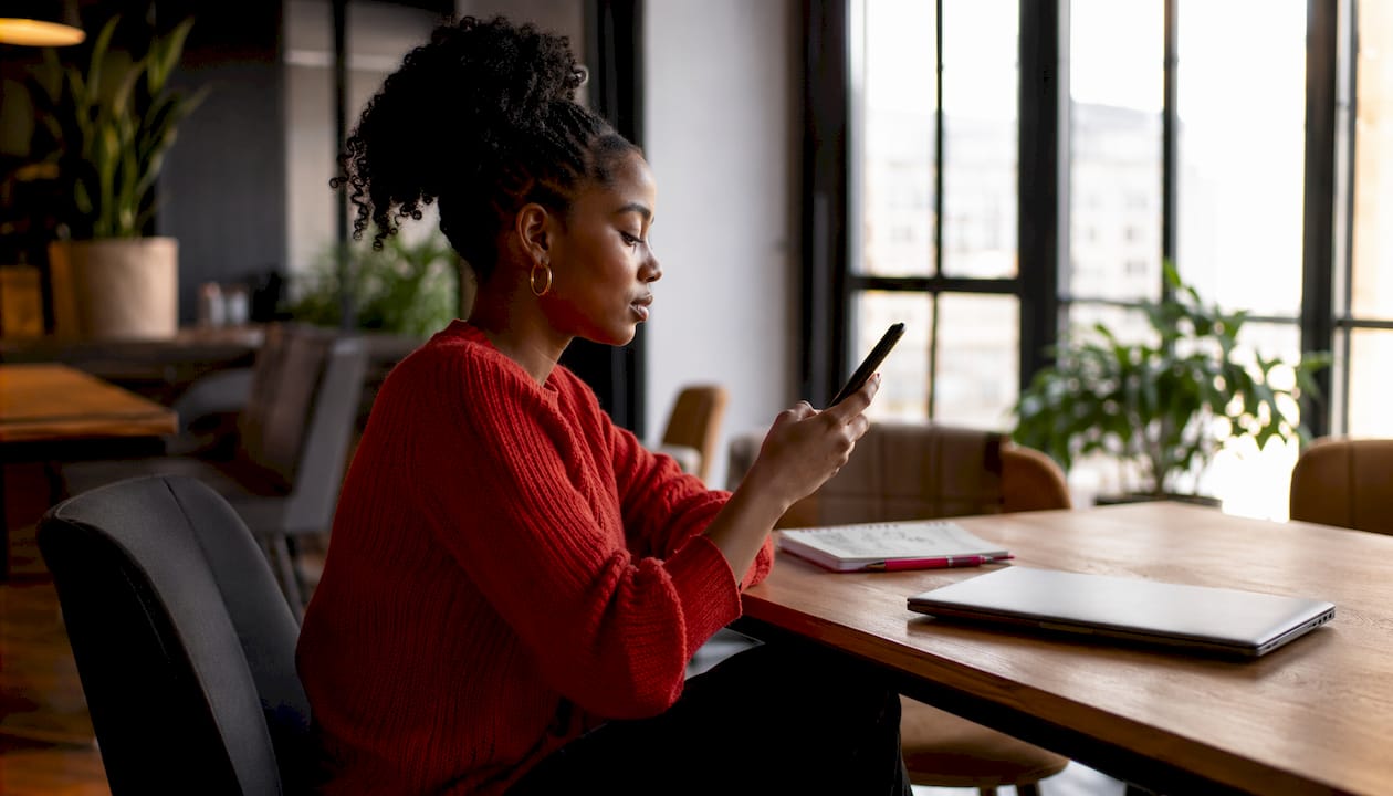 Woman using smartphone comparing retweet and quote tweet