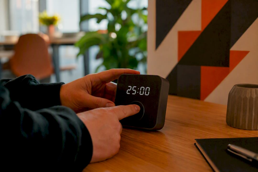 Un employé règle un minuteur sur son bureau dans une petite entreprise.