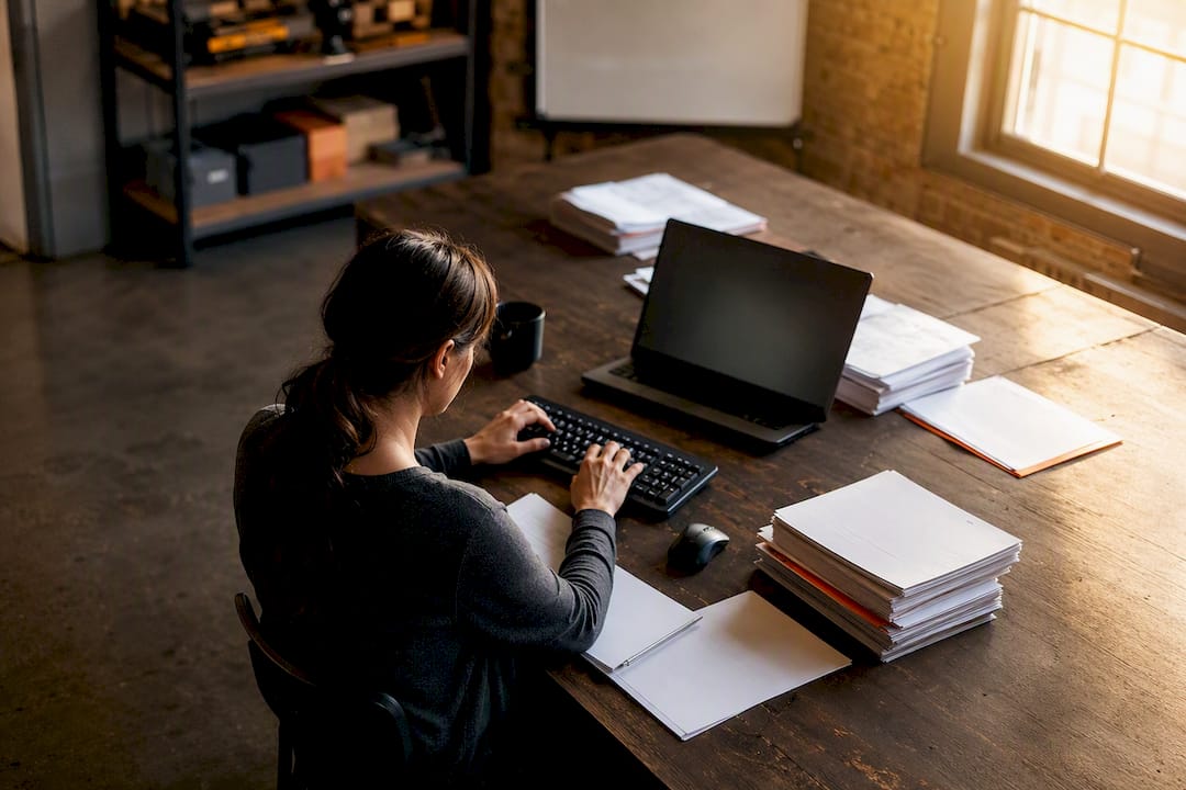 Mains tapant des données d'événements de paie au bureau
