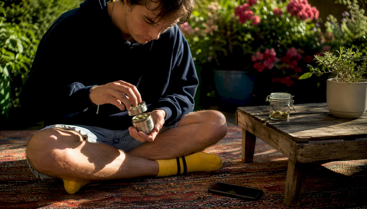 Person using grinder to collect kief at home